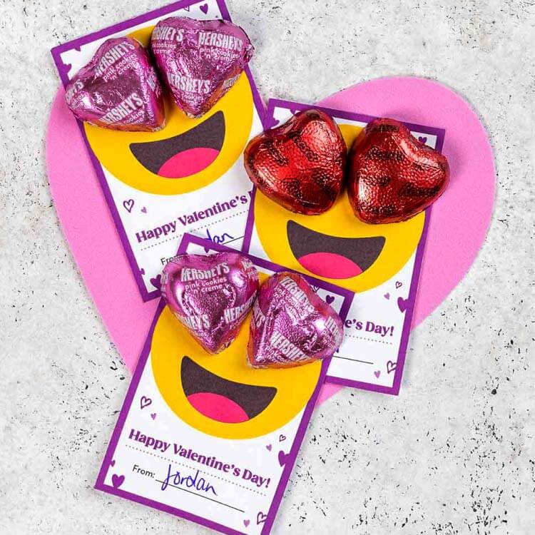 emoji valentines exchange cards topped with hersheys and reeses hearts candy